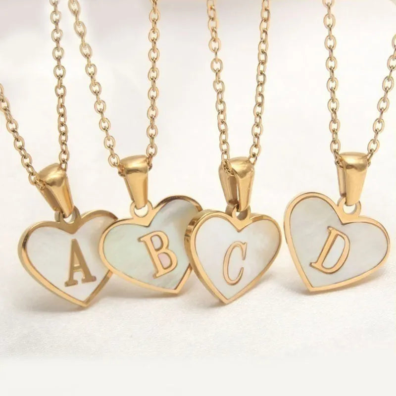 Gold heart-shaped white shell necklace with personalised letter charm on adjustable chain