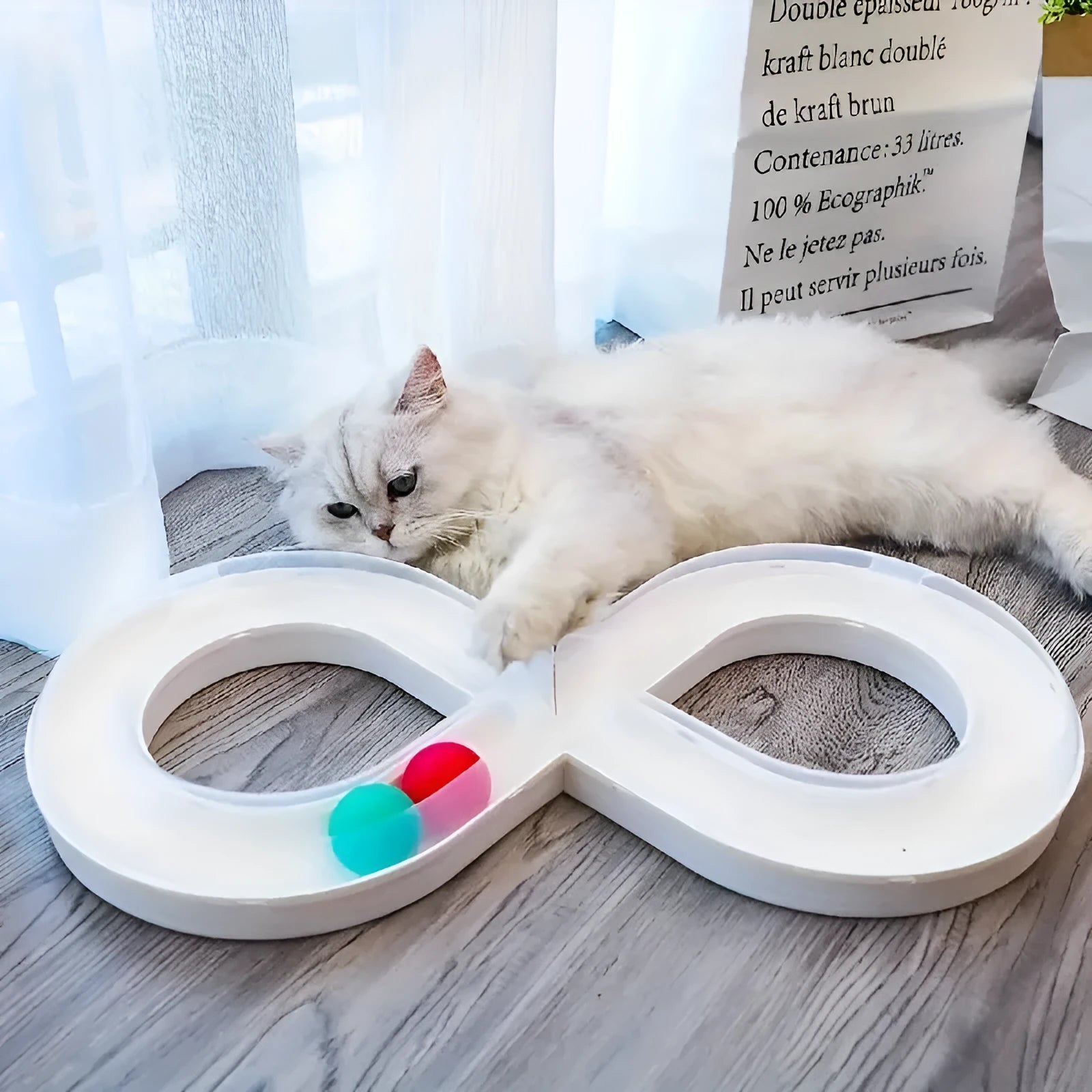 Blue and white cat toy set with a turntable track ball and a teasing stick on a floor.
