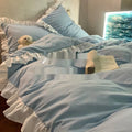 Mori style washed linen four-piece bedding set in a solid colour, shown on a bed.