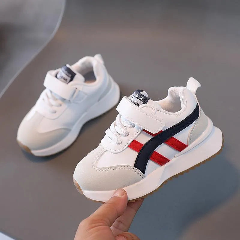 Children's white casual sneaker with Velcro closure showing synthetic leather upper and rubber sole