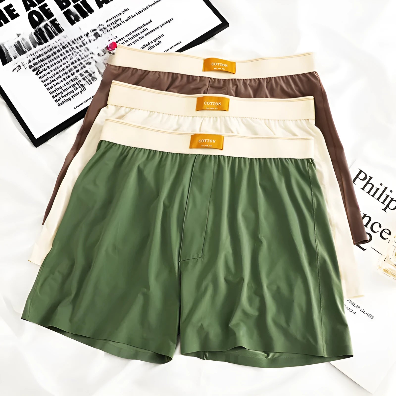 Pack of three pairs of solid colour men's loose fit ice silk underwear on a white background.