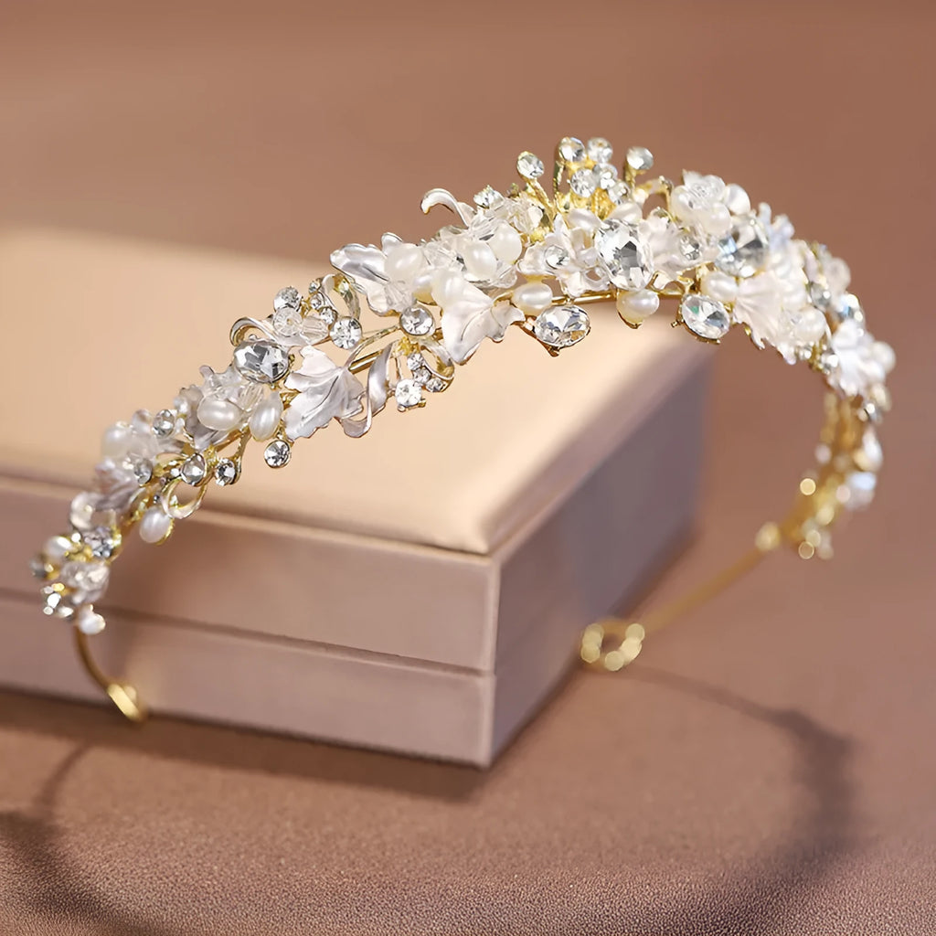 Gold metal alloy crown headdress with a white pearl-like decoration for women.