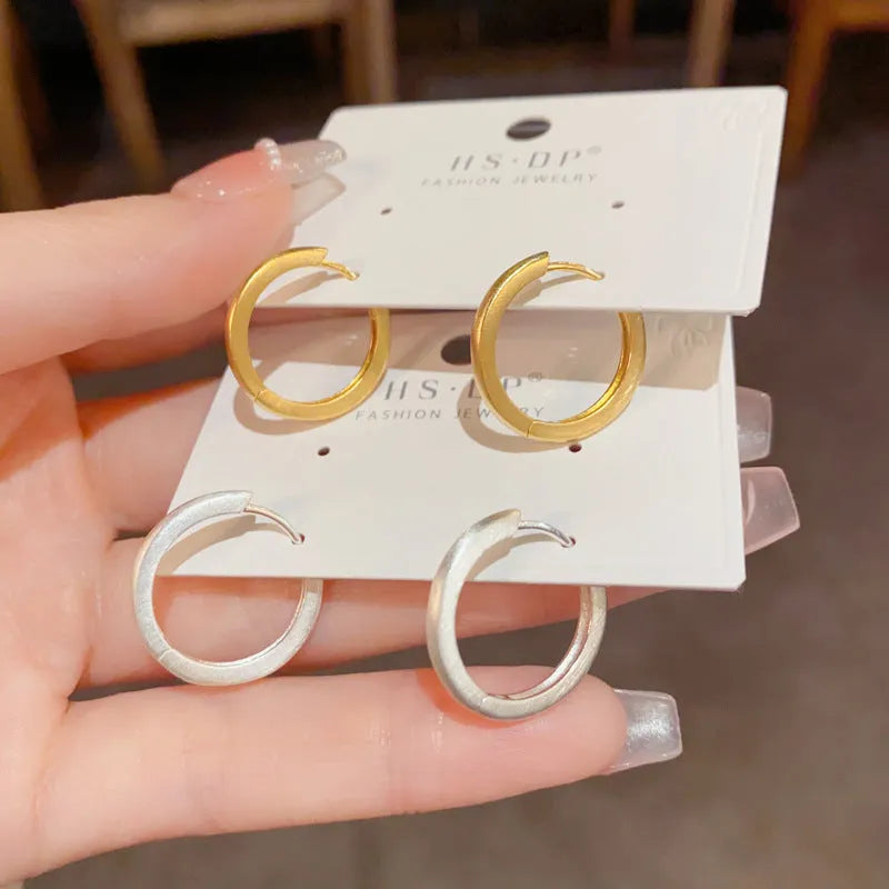 Geometric circle ear clips with gold plating and eyelet detail for women's pierced ears