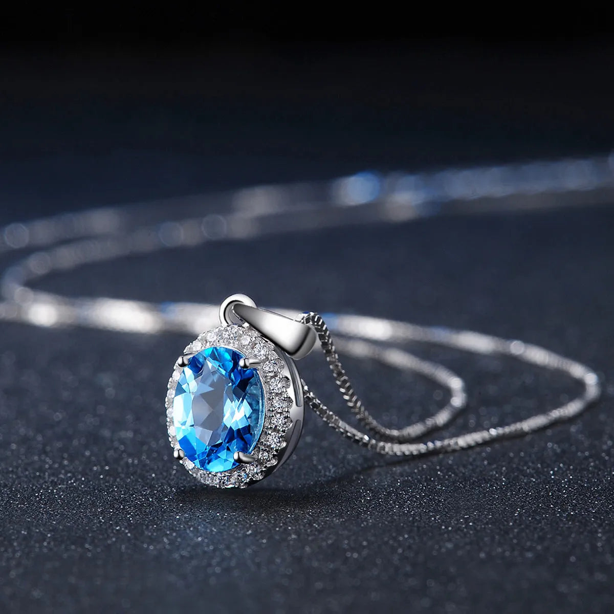 Women's sterling silver jewellery set with blue topaz gems featuring geometric earrings, ring, necklace and pendant