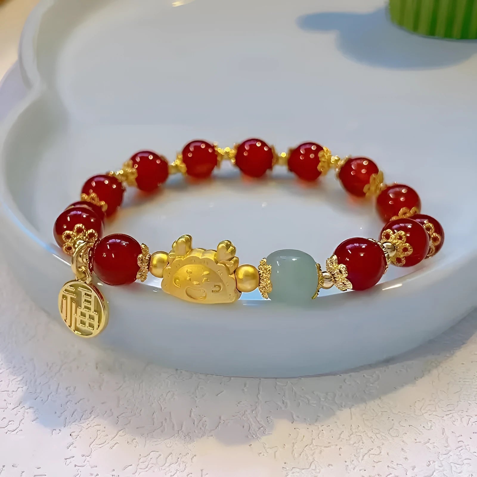 Women's glass and coloured glaze bracelet with zodiac animal design and red, pink, and white beads.