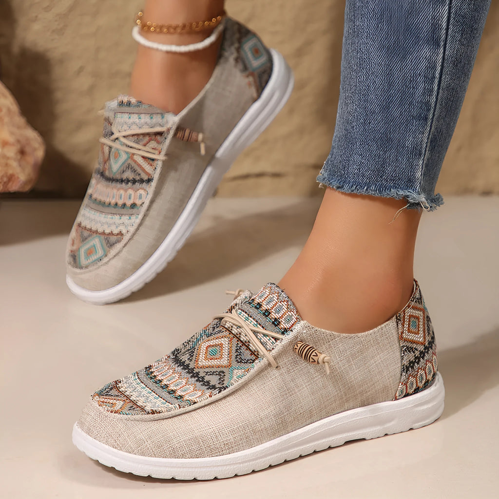 Women's black flat shoes with round toe and slip-on design on neutral background