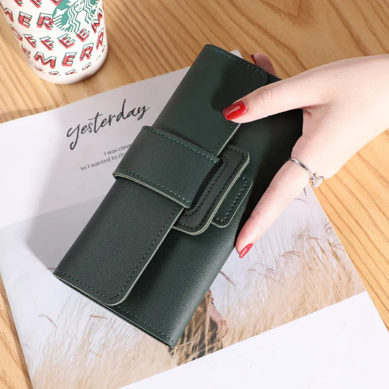 Women's long tri-fold wallet in light grey PU leather with sewing thread detail, open to show multiple card slots and cash compartments.