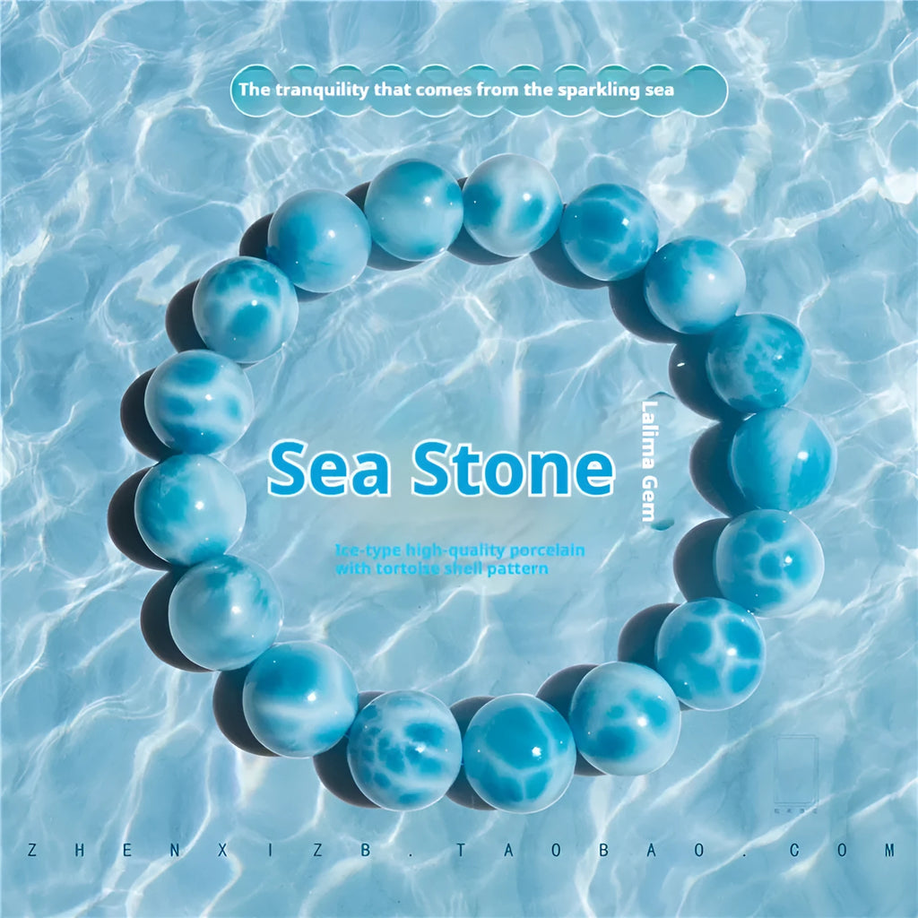 Blue Maillard-style Bodhi bracelet with a sea-pattern crystal stone and pearl accents on a wrist.