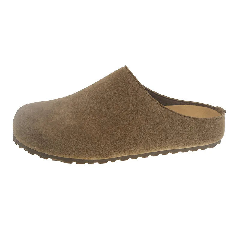 Flat apricot coloured slip-on slippers with a square toe and microfiber upper on a light surface.