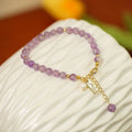 Natural crystal bracelet with romantic lavender amethyst beads, available in dark or light colour, on a plain background