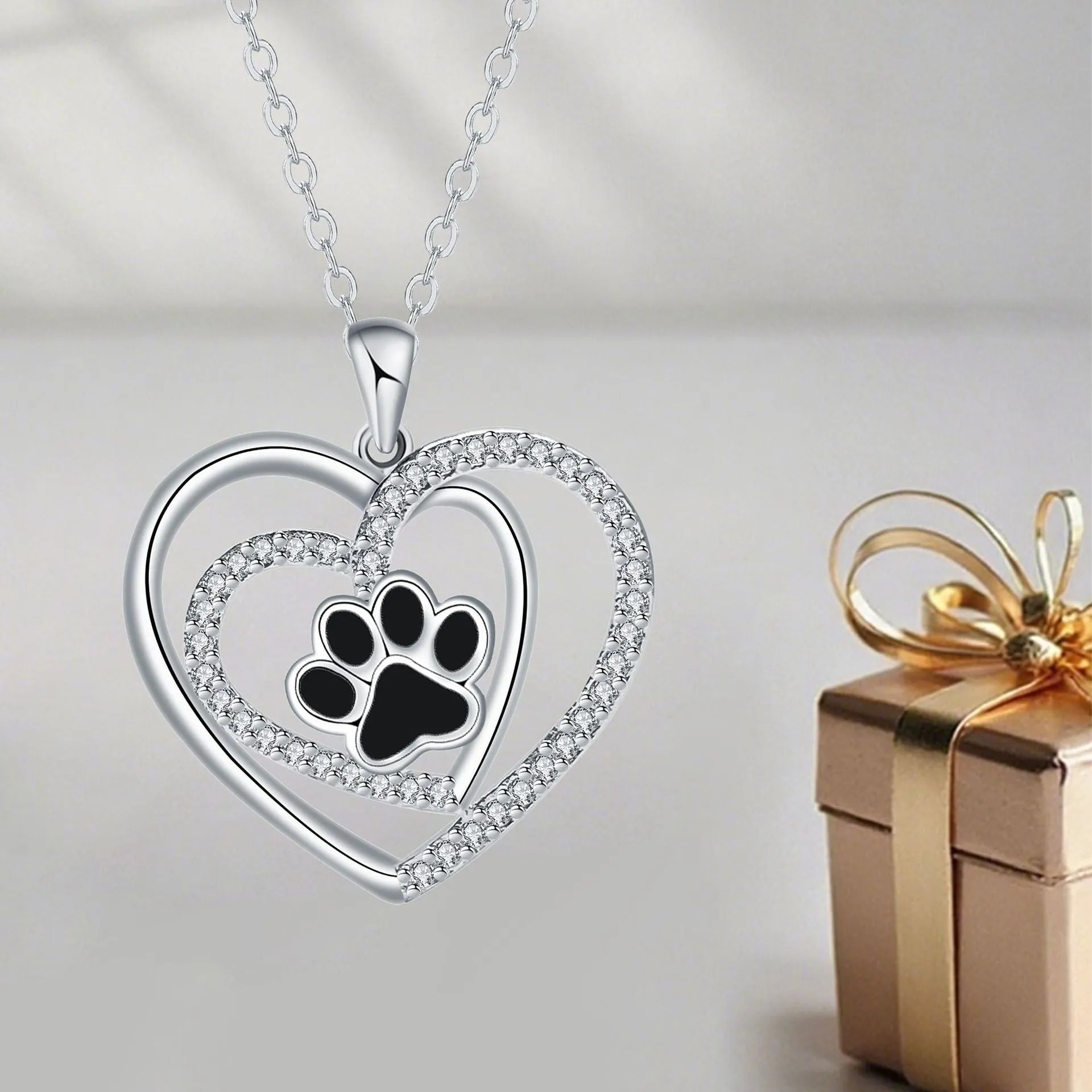 Copper heart pendant necklace with dog paw print detail on a cross chain.