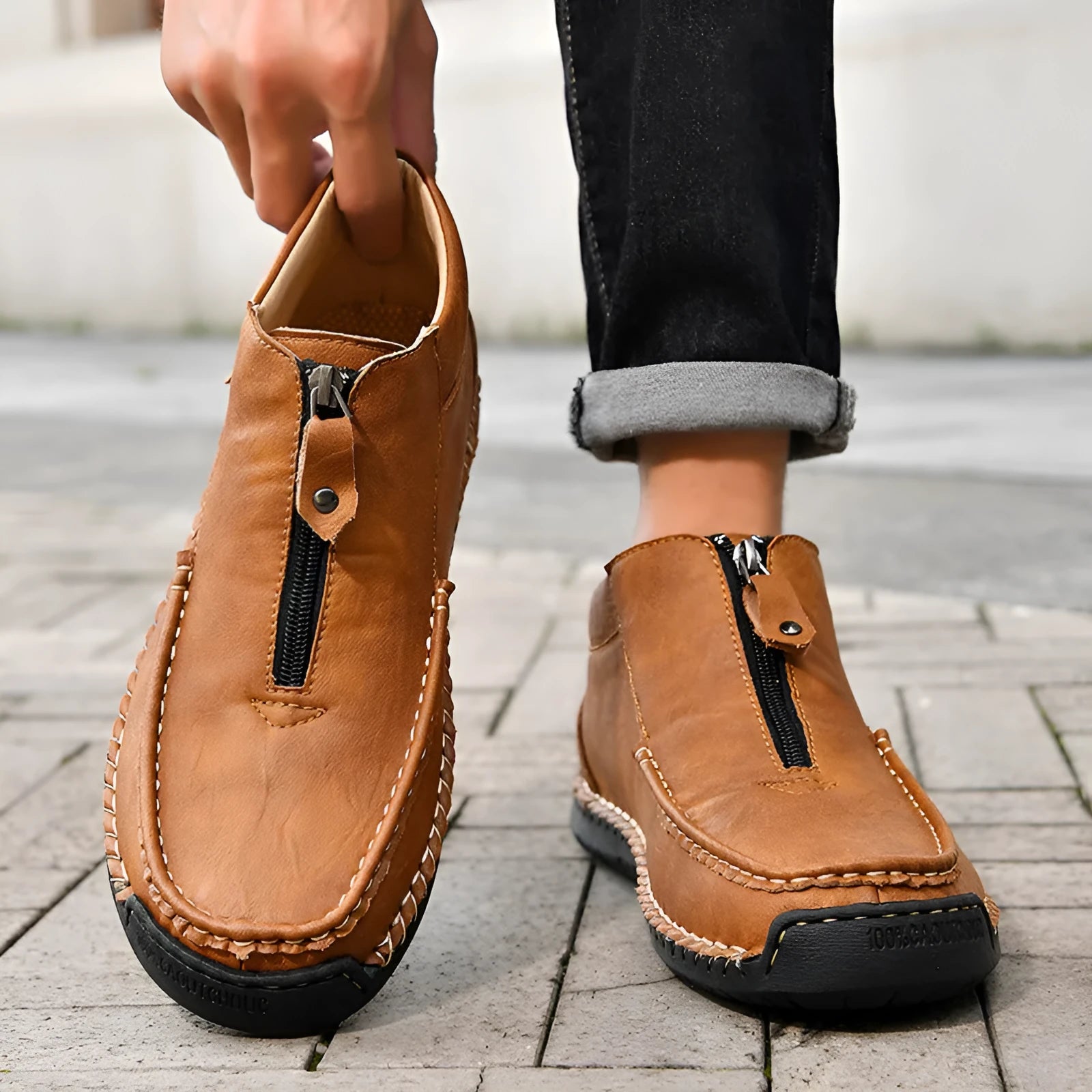 Men's black slip-on leather loafers with a round toe and flat rubber sole, shown on a foot.