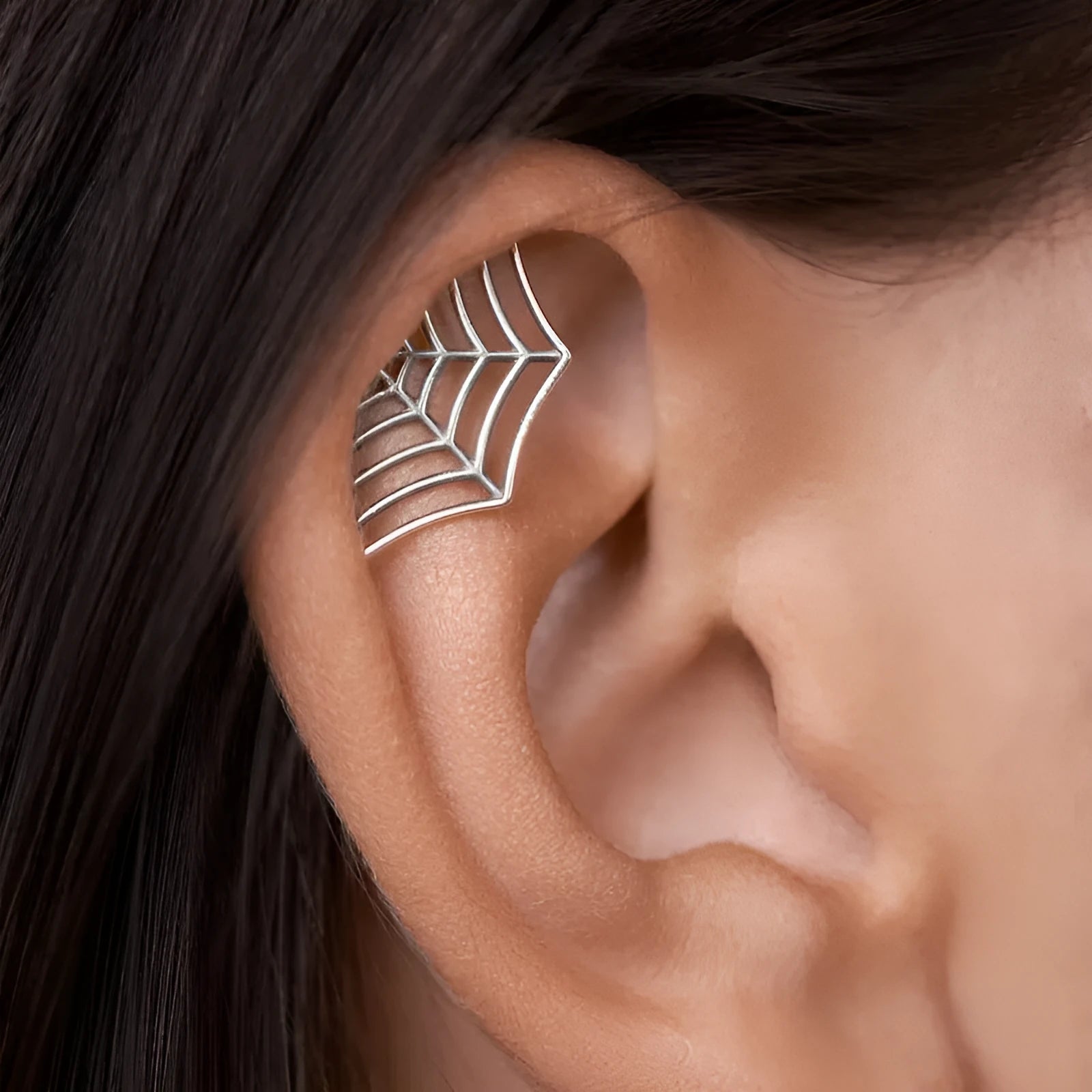 Spider web pattern stud earrings in gold and silver electroplated metal.