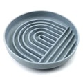 Silicone dog slow feeder bowl with ridge design in various colours on a kitchen counter.