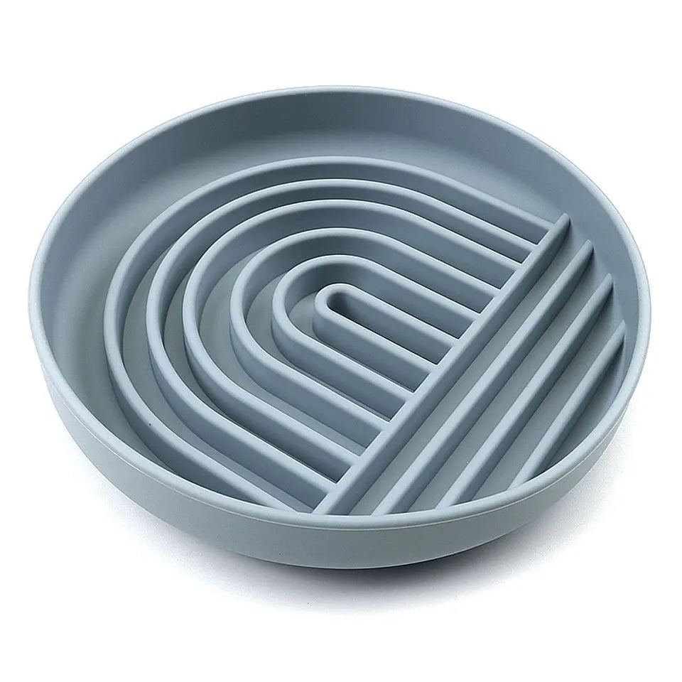 Silicone dog slow feeder bowl with ridge design in various colours on a kitchen counter.
