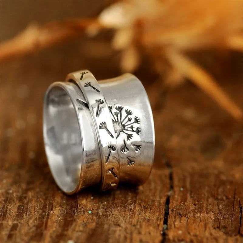 Silver rotating flower ring showing floral element and band details