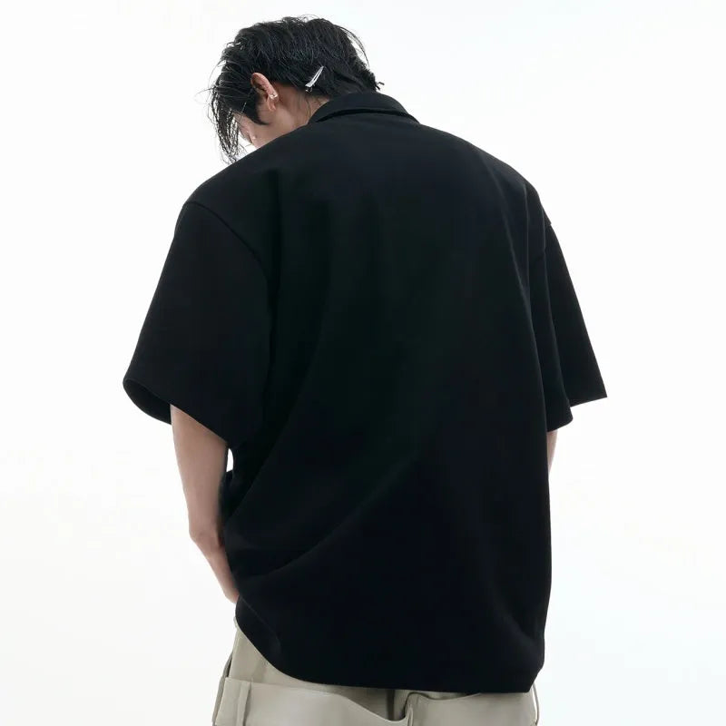 Men's black loose-fit polo shirt with a geometric grey and white pattern on the collar.