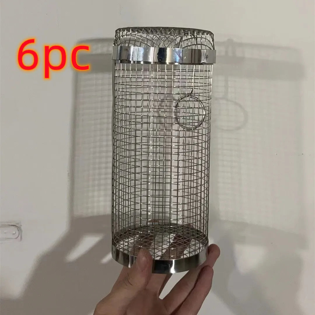 Rolling grill basket metal mesh cylinder with hooks on barbecue, containing vegetables and meat
