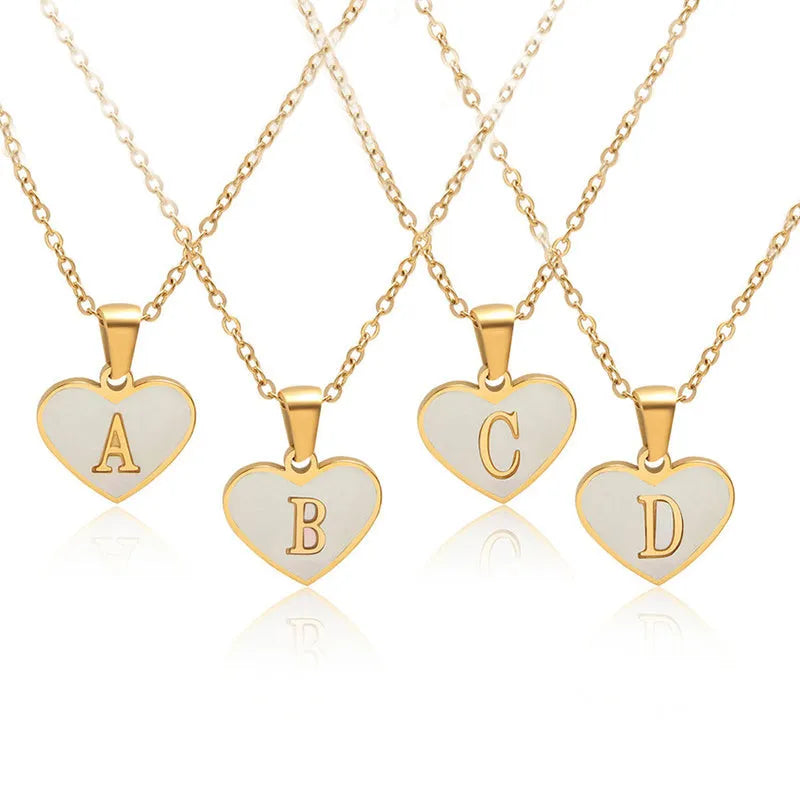 Gold heart-shaped white shell necklace with personalised letter charm on adjustable chain
