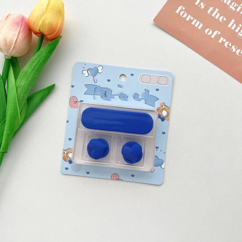 Colourful cartoon character plastic clip holding a magnetic charging cable on a desktop