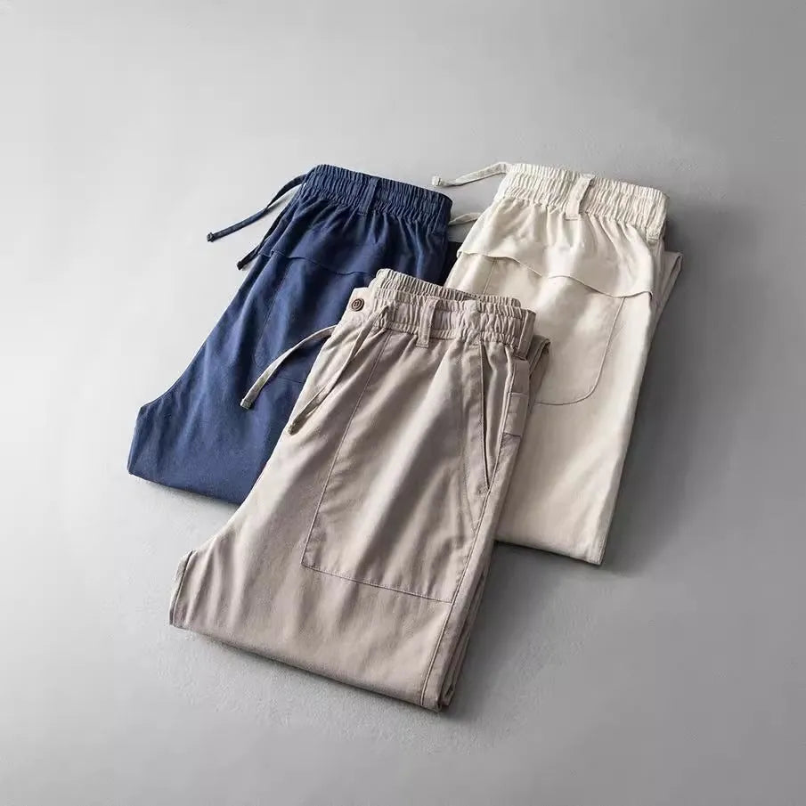 Men's linen casual trousers in navy blue, shown with a mid-waist and standard trouser length.