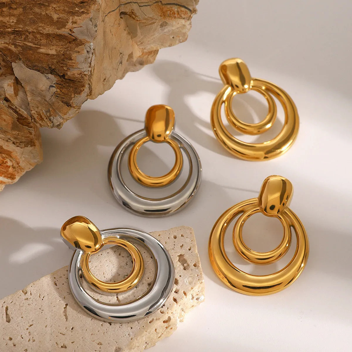 Round golden geometric hollow stud earrings made from titanium steel with an 18K gold electroplated finish.