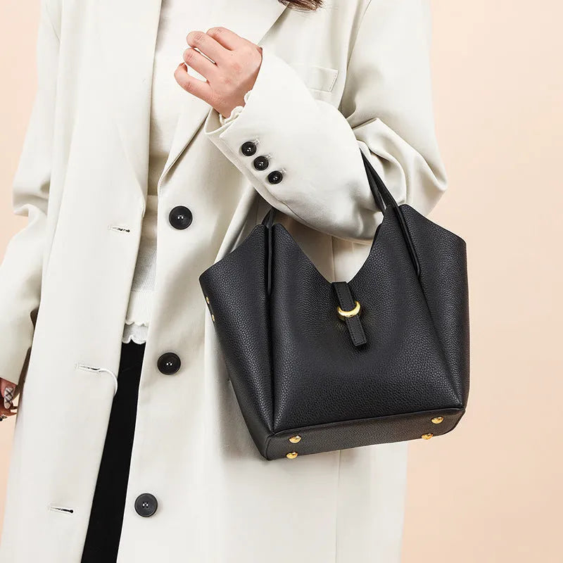 Genuine leather women's hand holding bucket bag in European American retro style with visible sewing thread detailing