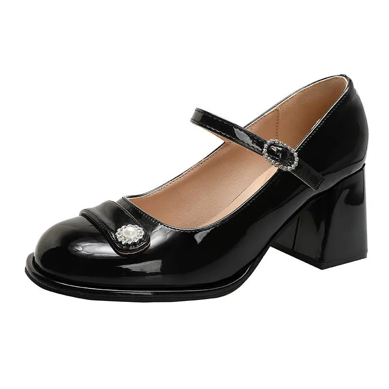 Women's black patent leather chunky heel shoes with round toe and buckle fastening on a white background.