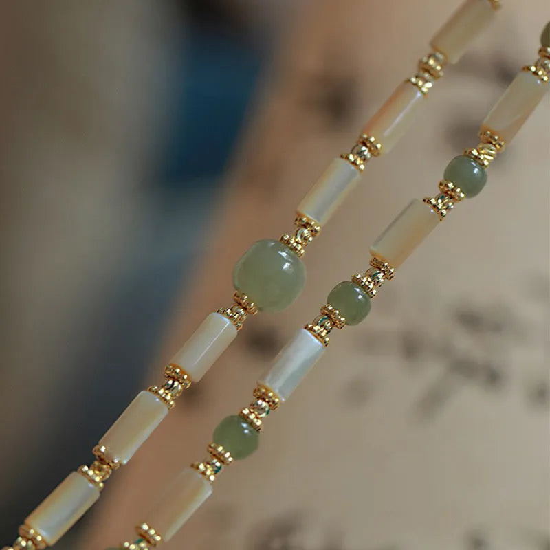 Natural Hetian jade and white lip shell round bead bracelet on neutral background, single bead option
