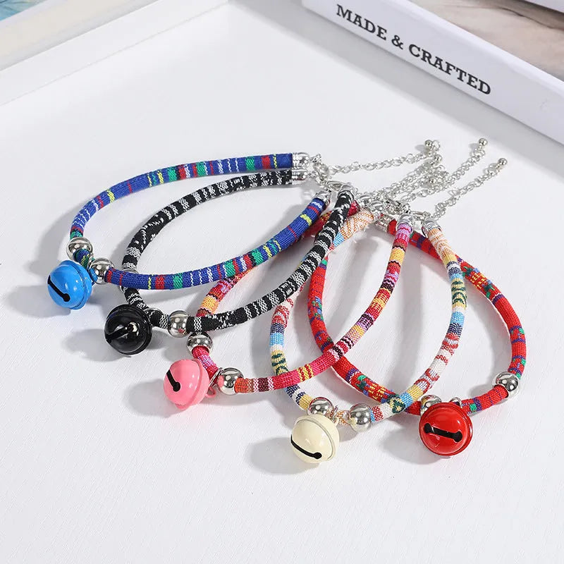 Coloured ethnic pattern adjustable pet collar for dog or cat with a small metal bell attached.