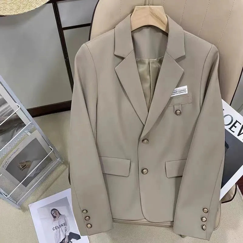 Black women's loose-fit short suit coat with long sleeves and a pocket.