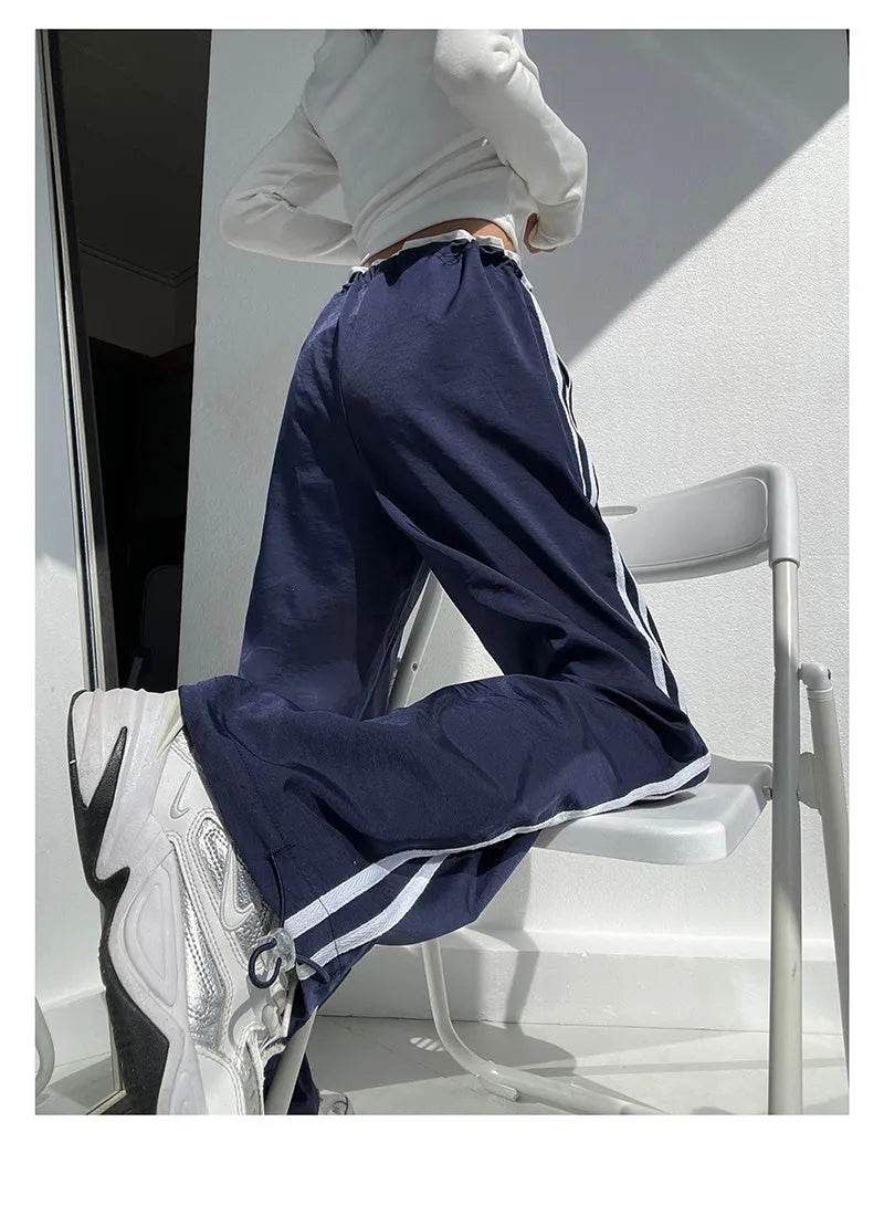 Navy blue loose straight-leg trousers with contrast detail, shown on a hanger.