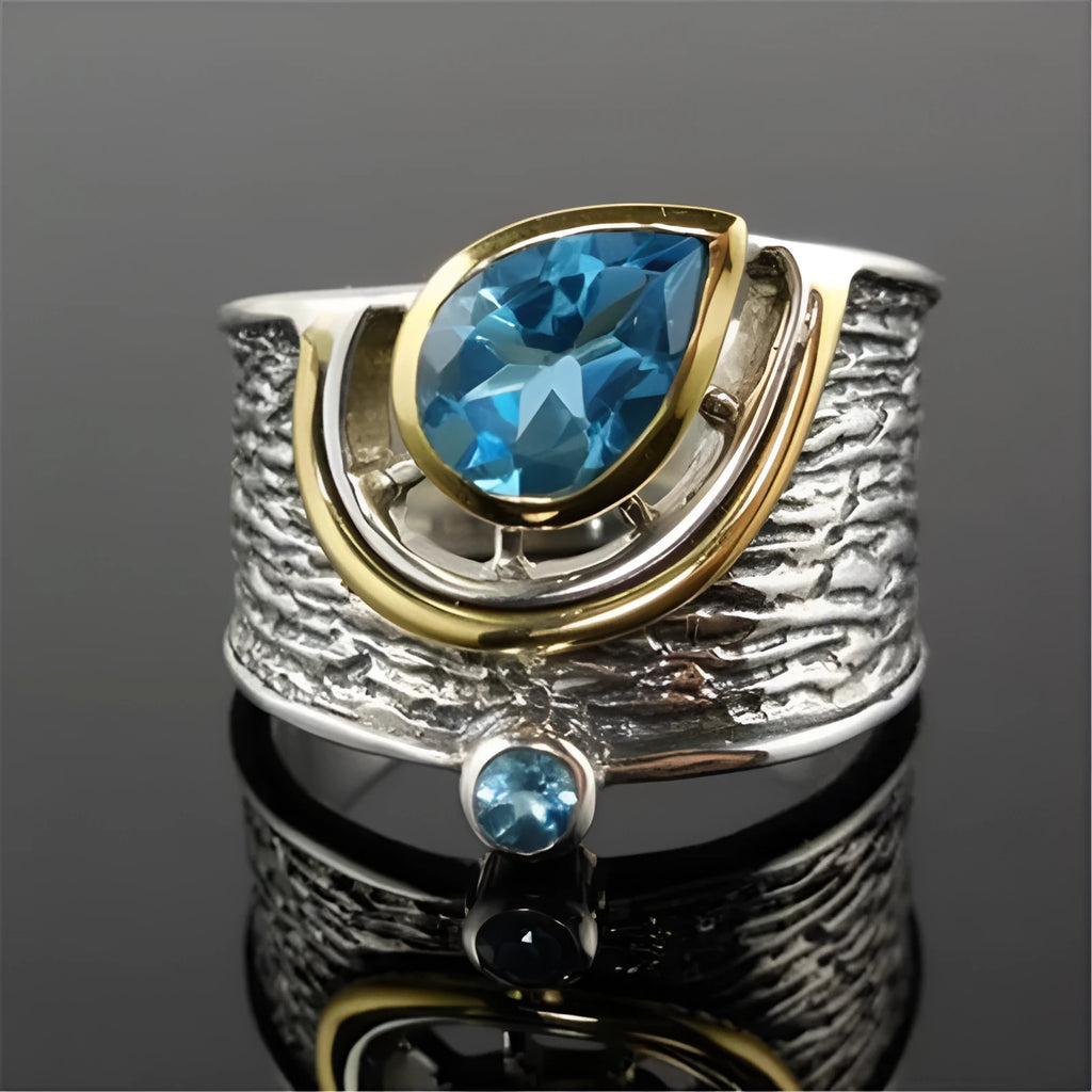 Blue rhinestone zircon drop shape ring on a white background, showing Chinese-inspired alloy design.