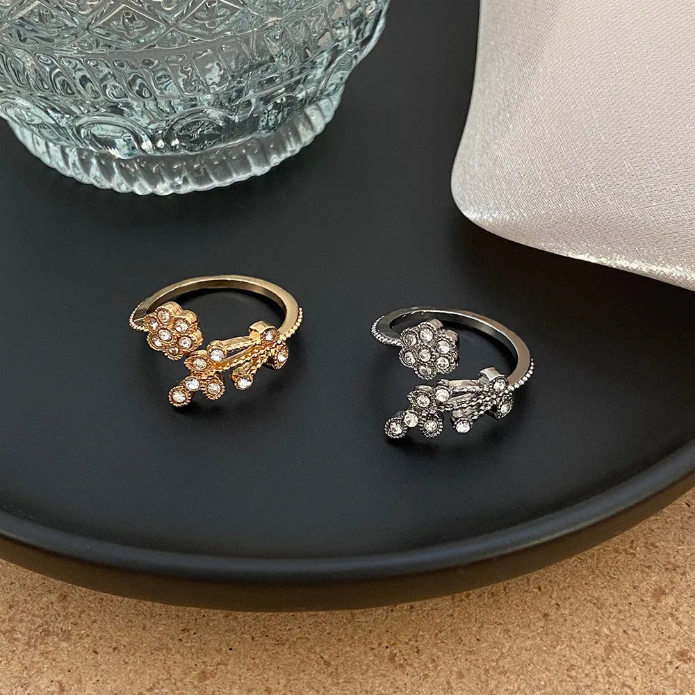 Women's open mouth copper ring with diamond-textured flower and leaves design in gold or white finish.