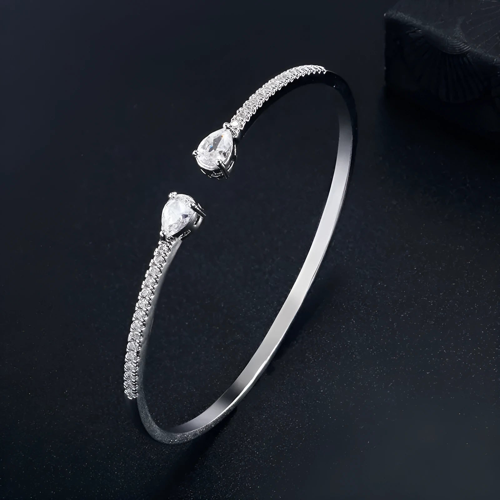 Copper bracelet with inlaid zircon stones in a simple style, shown in white and blue colour options.