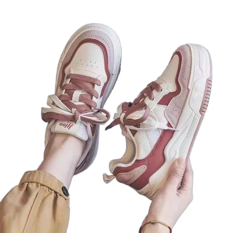 Women's low-top pink and white sneakers with a rubber sole and imitation leather lining.