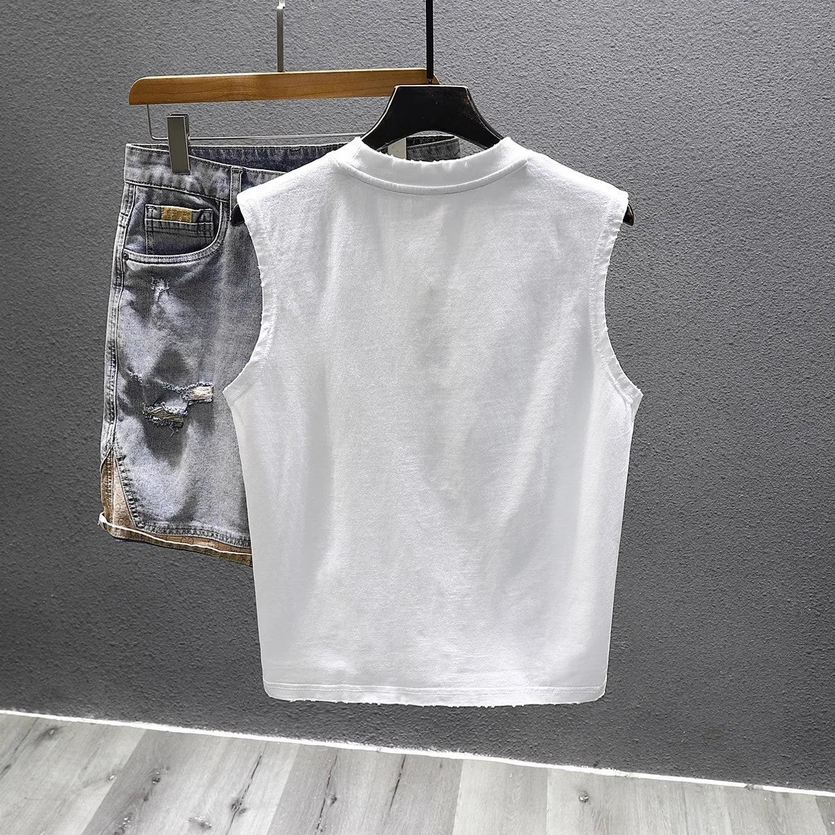 A white loose-fit cotton sleeveless t-shirt with a straight hem, laid flat.