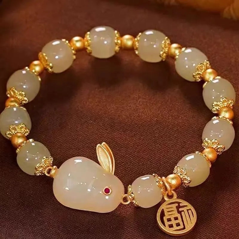Women's green jade bracelet with fu character hare pendant and lily element on black adjustable cord