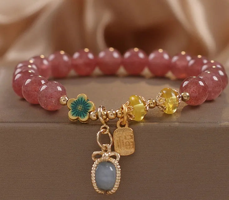 Natural strawberry quartz beaded bracelet red alloy with rhinestone details on white background
