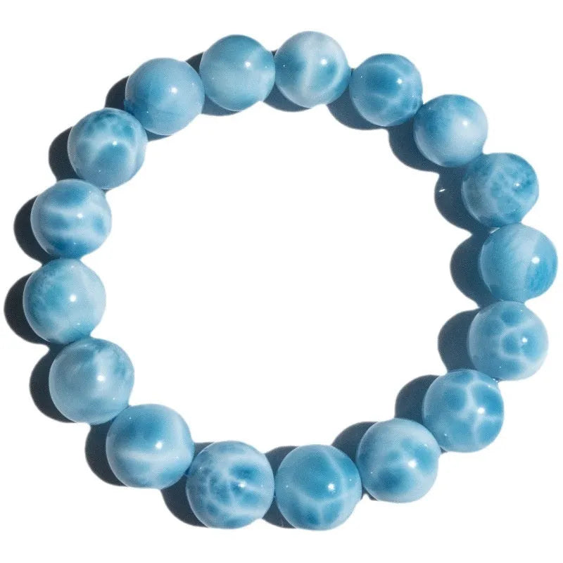 Blue Maillard-style Bodhi bracelet with a sea-pattern crystal stone and pearl accents on a wrist.