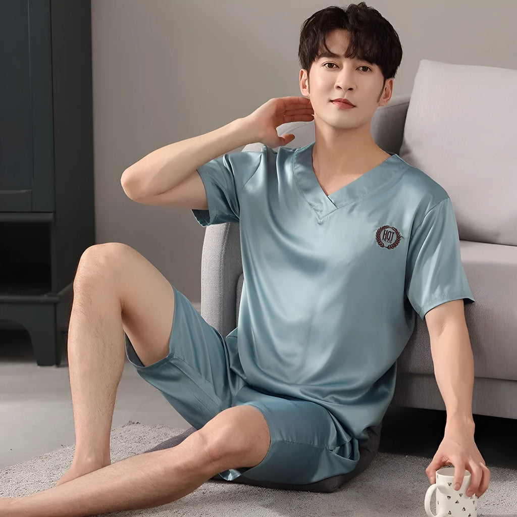 Man wearing a light blue short-sleeve ice silk pajama top and matching loose shorts.