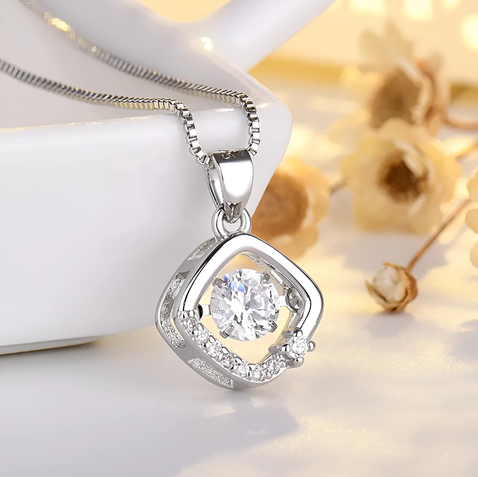 Silver tone heart pendant necklace with crown and bow charm on a model.