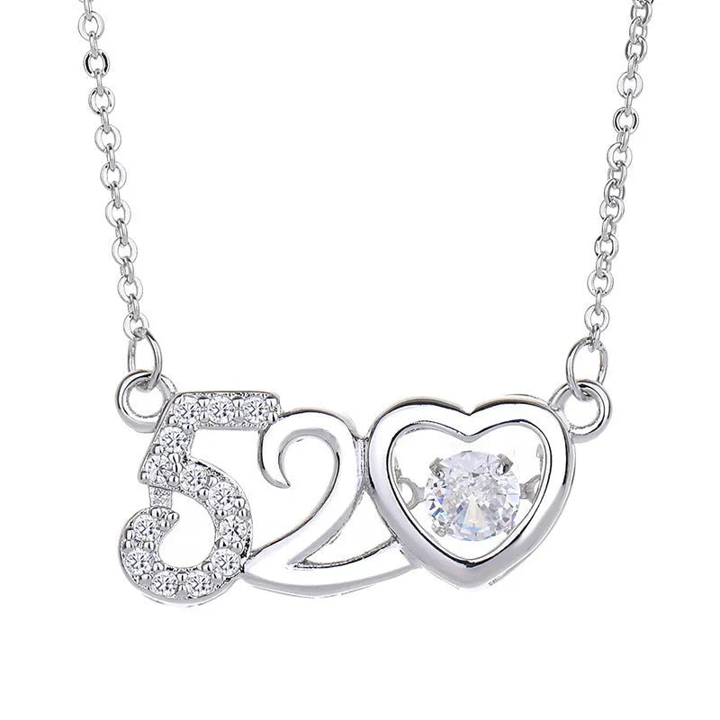 Silver tone heart pendant necklace with crown and bow charm on a model.