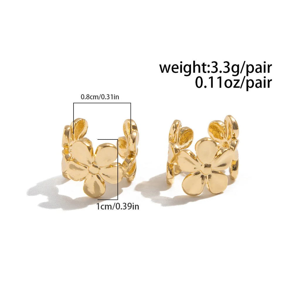Women's gold starfish and conch shell drop earrings on white background