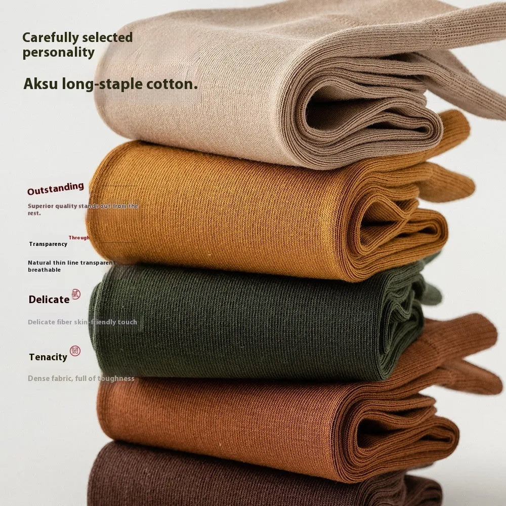 Pack of men's solid colour mid-calf business socks in combed cotton on a neutral background.