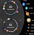 Two natural stone beaded zodiac sign bracelets with adjustable elastic straps on a wooden surface.
