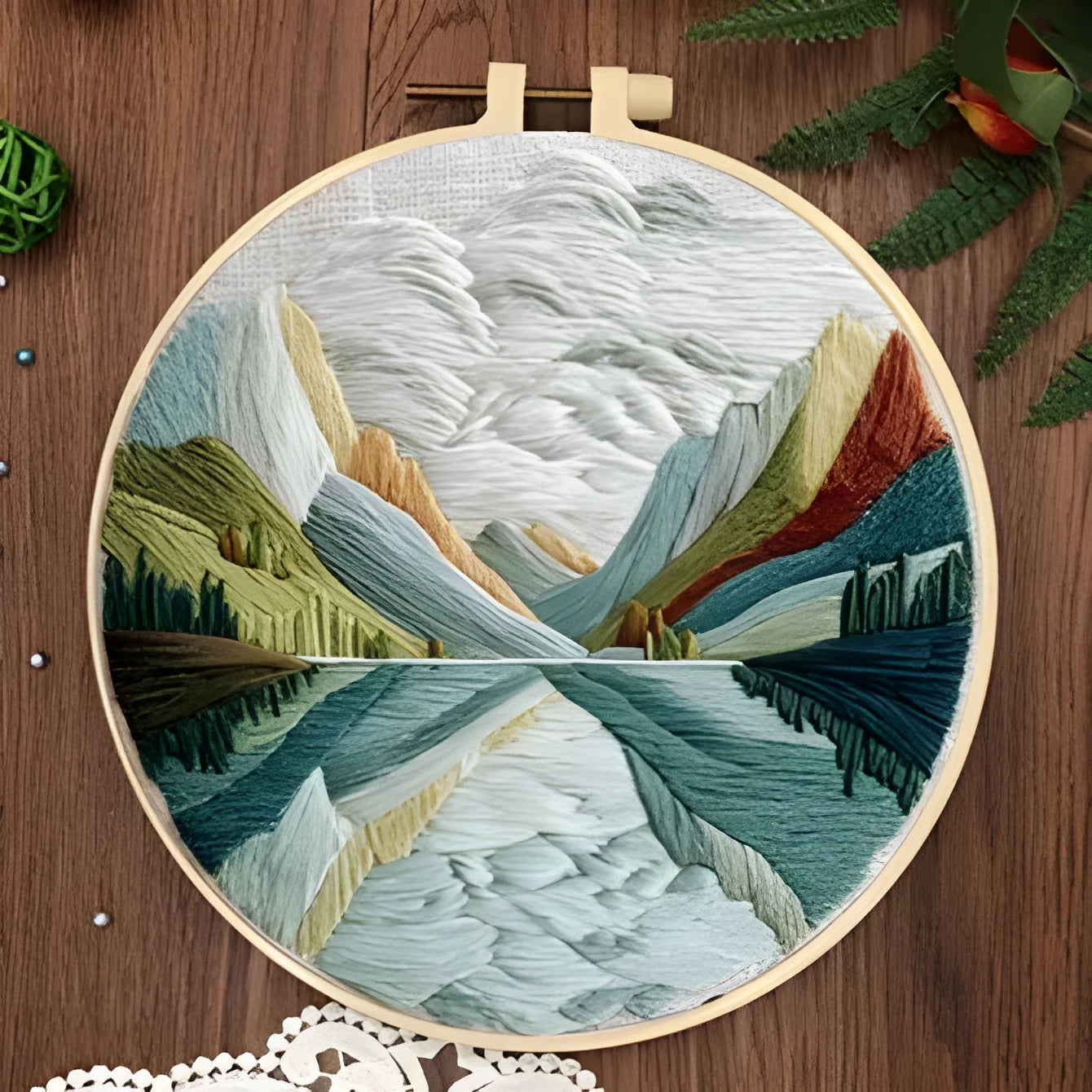 Embroidery DIY landscape kit with cotton fabric, bamboo frame, threads, and needles for handmade cloth art.