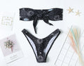 Black women's one-piece swimsuit with bikini print pattern and low back design
