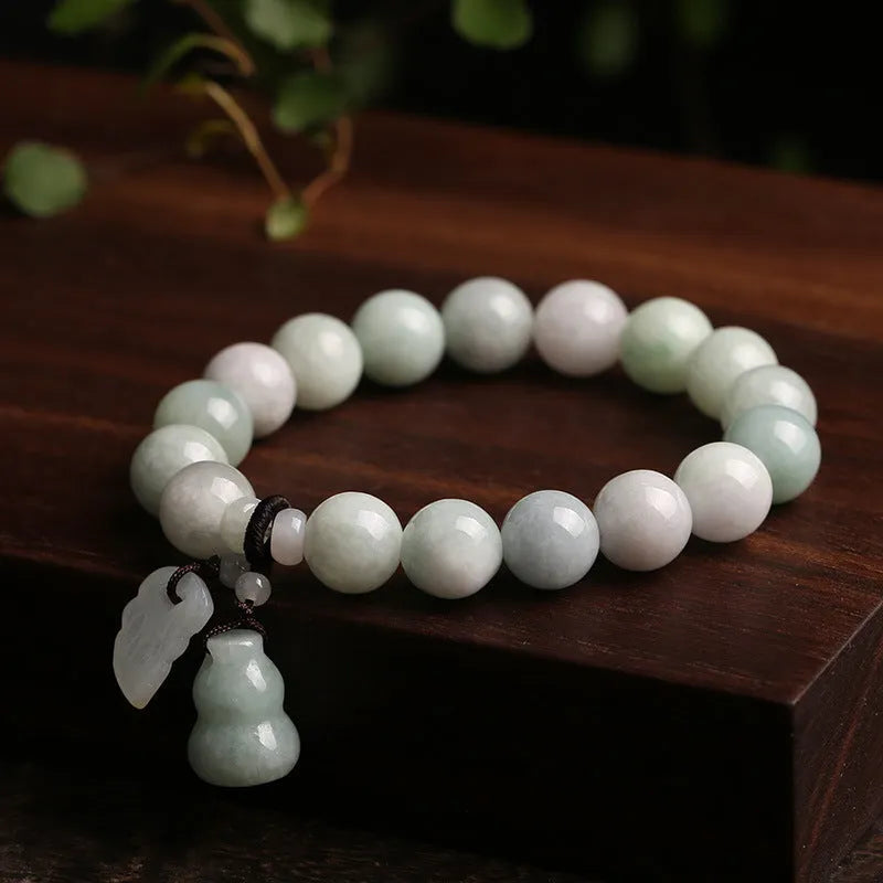 Natural emerald green jade hanging bracelet with Maitreya Buddha design on a geometric shape.