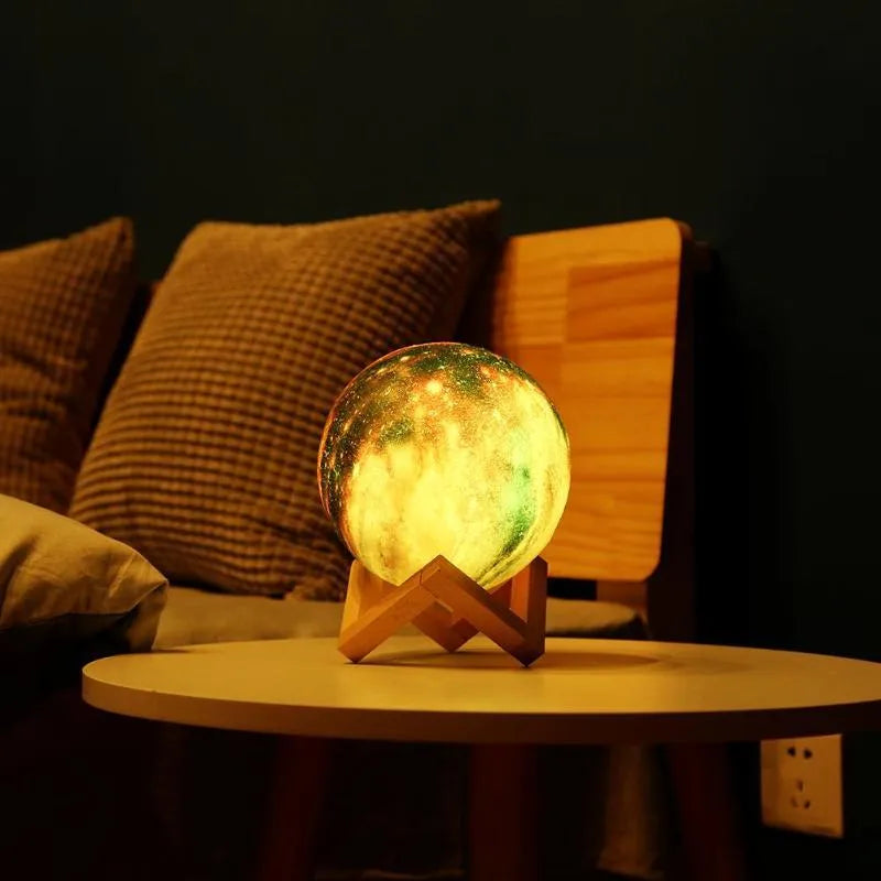 3D printed spherical lunar night light with multi-colour LED glow on a dark surface.